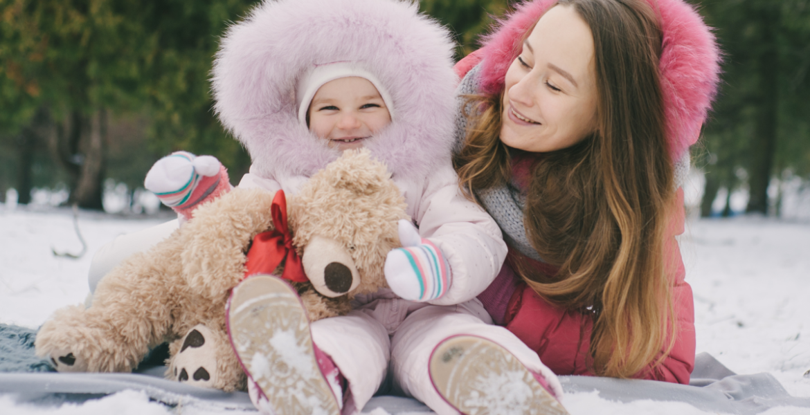 Mamá y bebé disfrutando del invierno abrigados, mostrando la importancia de proteger la piel del bebé del frío.