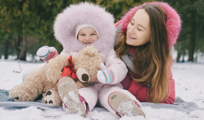 Mamá y bebé disfrutando del invierno abrigados, mostrando la importancia de proteger la piel del bebé del frío.