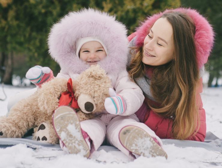 Mamá y bebé disfrutando del invierno abrigados, mostrando la importancia de proteger la piel del bebé del frío.