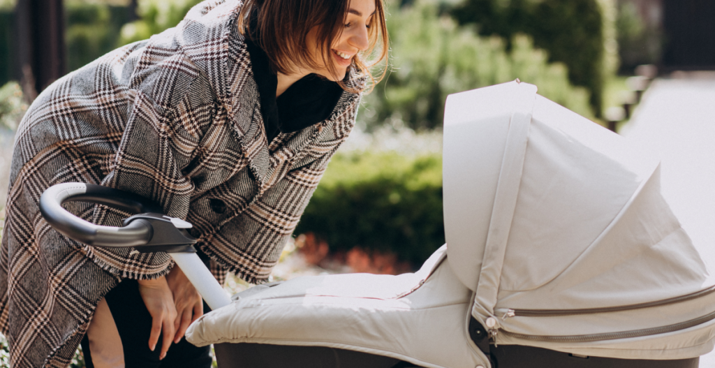 Mamá paseando con carrito en un día frío.