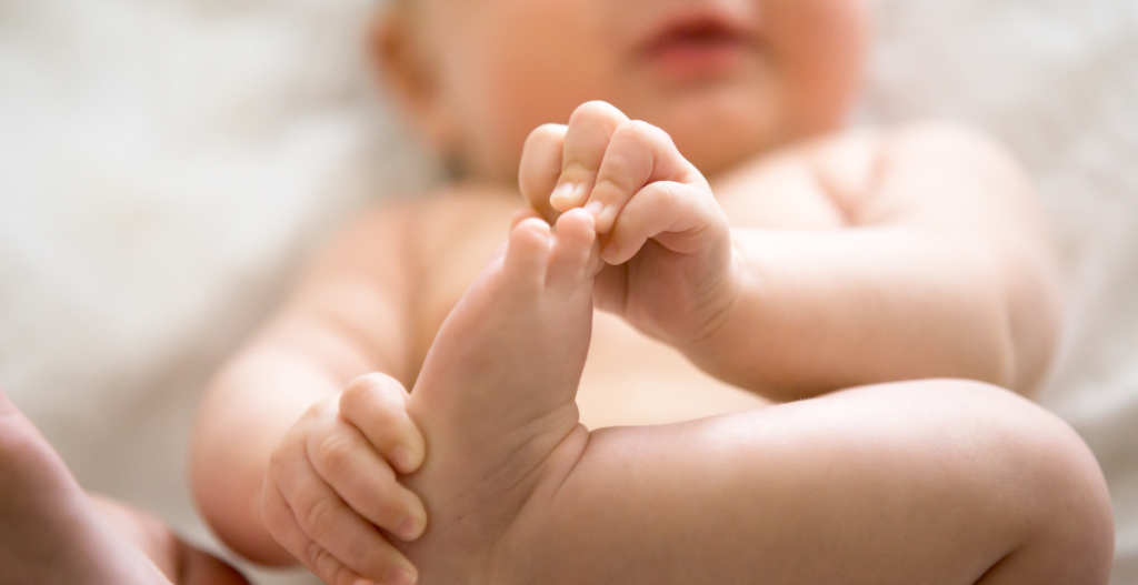 Primer plano de los pies de un bebé, simbolizando la delicadeza de la piel infantil y la necesidad de cuidarla en invierno.