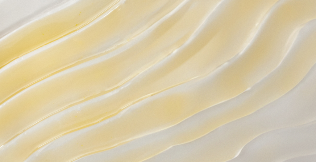 textura de retinal dorada semitransparente con un patrón rugoso o microgranulado sobre un fondo beige claro.