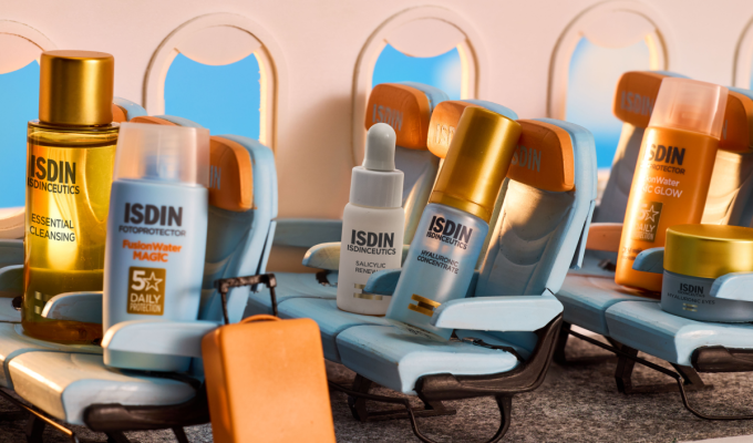 Productos Mini Icons de ISDIN colocados en asientos de avión simulando una escena de viaje