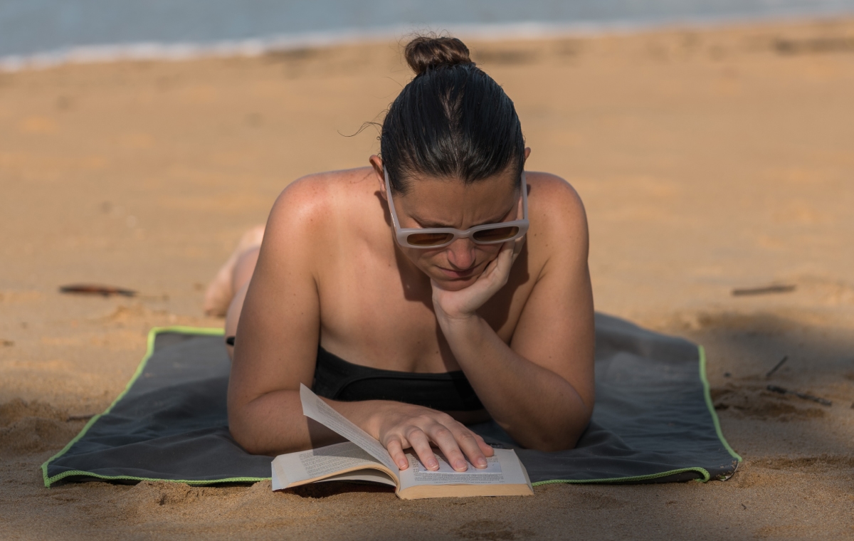 chica leyendo libro en la playa