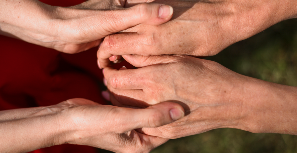Varias manos sosteniendo otras manos adultas, símbolo de apoyo, acompañamiento y cuidado durante la menopausia.