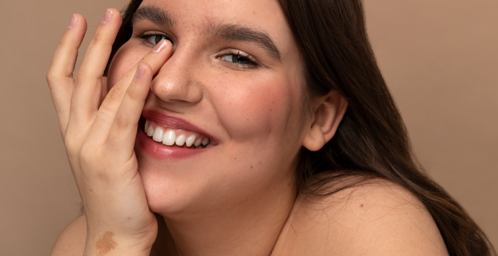 Persona sonriendo con piel fresca y luminosa después de aplicar protector solar facial con color.