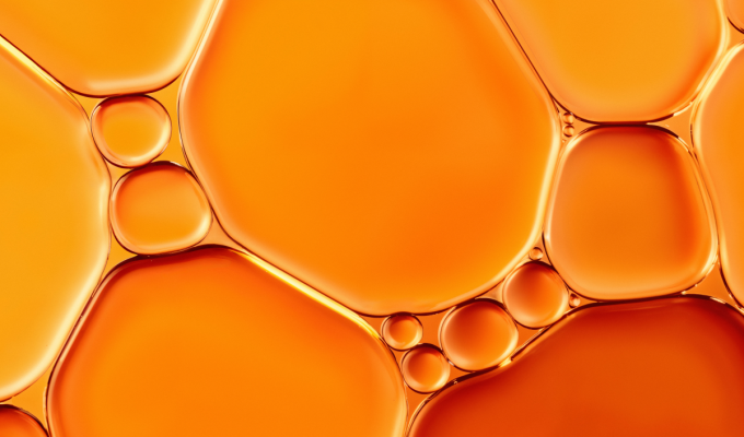 Textura líquida en tonos naranjas que representa la vitamina C y su acción antioxidante en la piel