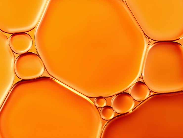 Textura líquida en tonos naranjas que representa la vitamina C y su acción antioxidante en la piel