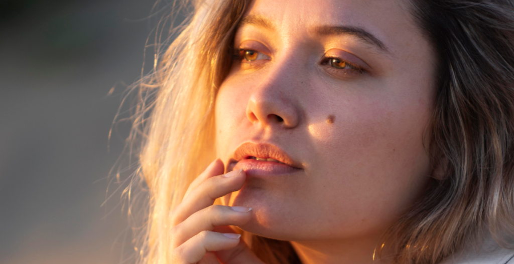 Mujer con piel luminosa al atardecer, reflejando una rutina facial de primavera con vitamina C