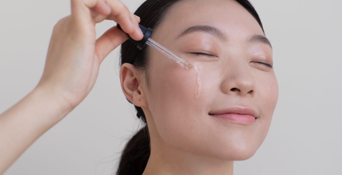 Mujer aplicando sérum facial con gotero en la mejilla, parte de la rutina de skin cycling para hidratar y regenerar la piel