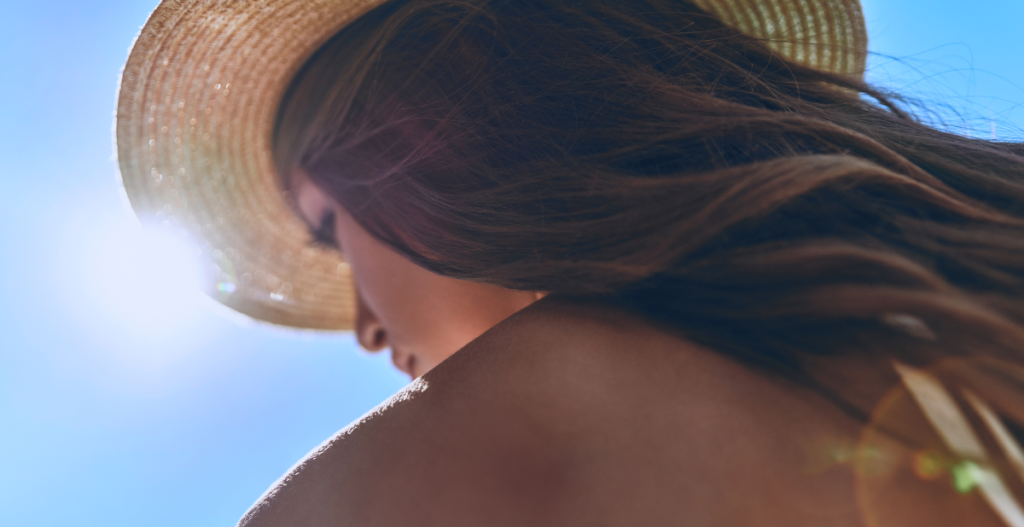 Mujer al sol protegiendo su piel como parte de la rutina skincare por estaciones en verano