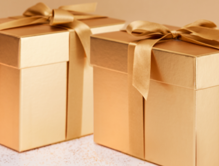 Cajas de regalo doradas con lazo sobre fondo claro, representando ideas de regalo de Navidad elegantes y sofisticadas