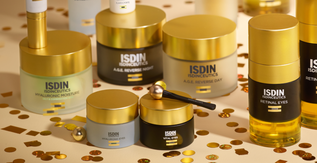 Selección de productos de cuidado facial ISDIN con envases dorados sobre fondo elegante, ideales como ideas de regalo de Navidad para el cuidado de la piel