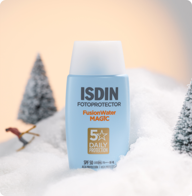 Protector solar ISDIN Fusion Water MAGIC SPF 50 sobre nieve, representando protección diaria en invierno, una práctica idea de regalo de Navidad