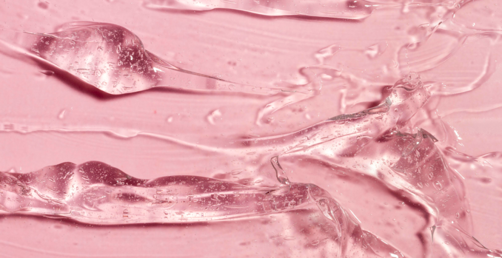 Textura rosa de sérum hidratante en gel, asociada al cuidado well-aging para prevenir arrugas y aportar luminosidad.