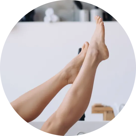 Piernas elevadas con pies cuidados en un ambiente interior, imagen de bienestar y tratamiento diario para pies y talones secos