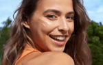 Primer plano de mujer con crema facial en la mejilla, rutina de protección solar para una piel radiante