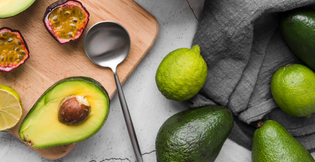 Aguacate, lima y fruta fresca sobre tabla que representan ingredientes naturales asociados al cuidado de la piel