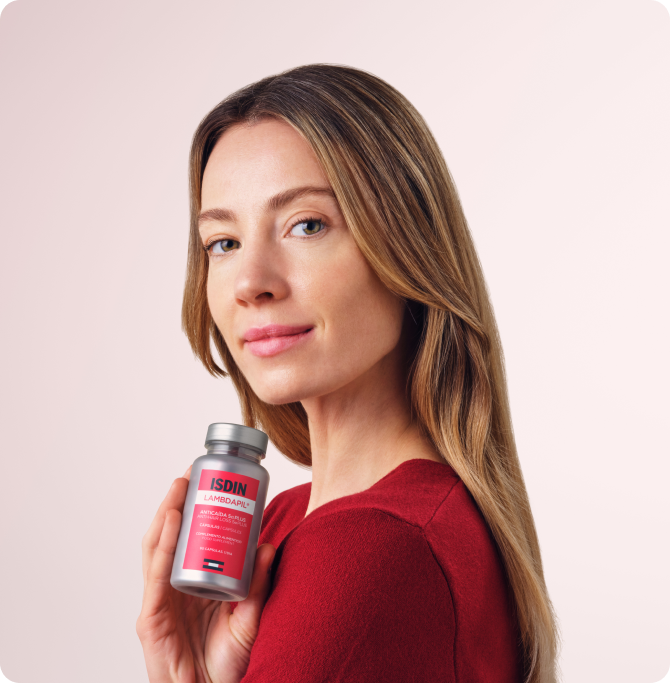 Mujer sosteniendo un envase de Lambdapil 5 Alfa Plus para el cuidado de la caída del cabello
