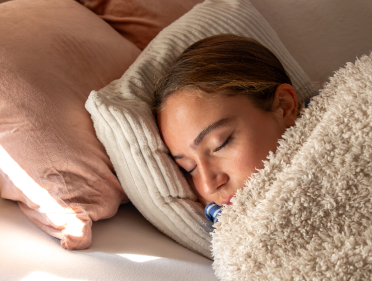 Persona durmiendo cómodamente bajo una manta suave, ejemplo de descanso profundo durante la noche.