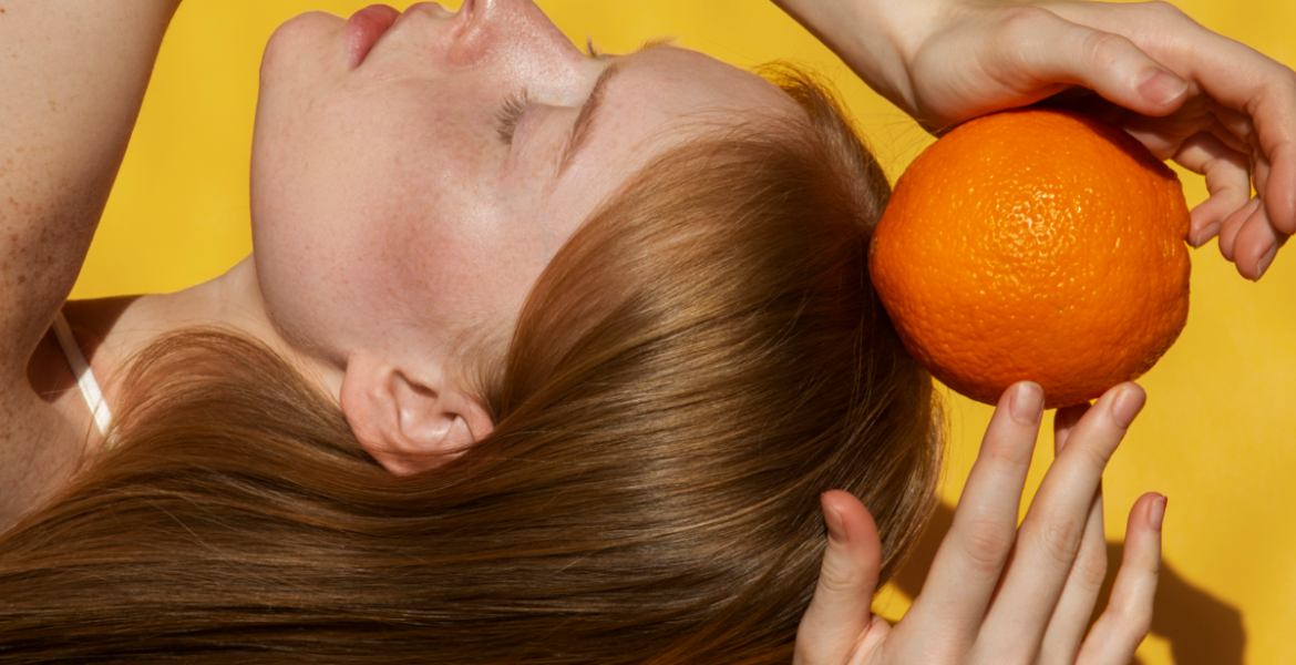 chica sujetando vitamina C naranja