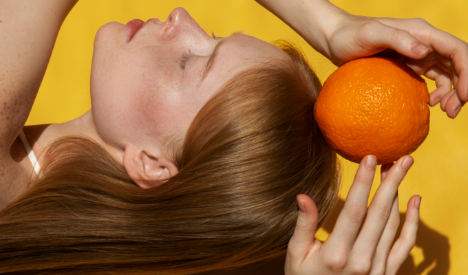 chica sujetando vitamina C naranja
