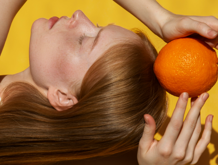 chica sujetando vitamina C naranja