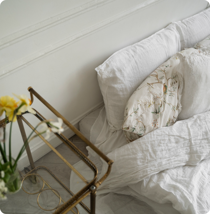 Dormitorio tranquilo con ropa de cama blanca y almohadas, un entorno ordenado y relajante que favorece un buen descanso.