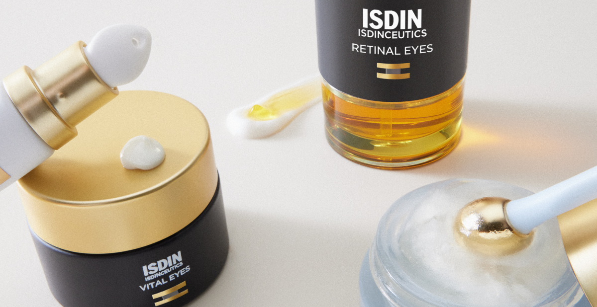 Envase de contorno de ojos ISDIN con tapa dorada y base transparente junto a una muestra de la textura cremosa en color blanco, sobre fondo neutro.