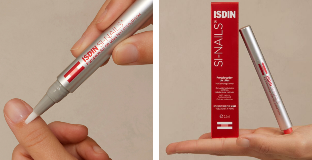 Primer plano de una mano aplicando el fortalecedor de uñas ISDIN Si-Nails sobre la uña del pulgar. Fortalecedor de uñas con ácido hialurónico y silicio.