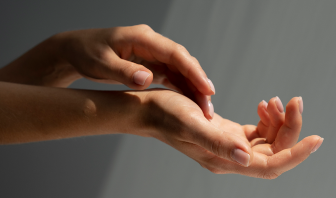 Manos con uñas cuidadas iluminadas suavemente, mostrando un aspecto saludable