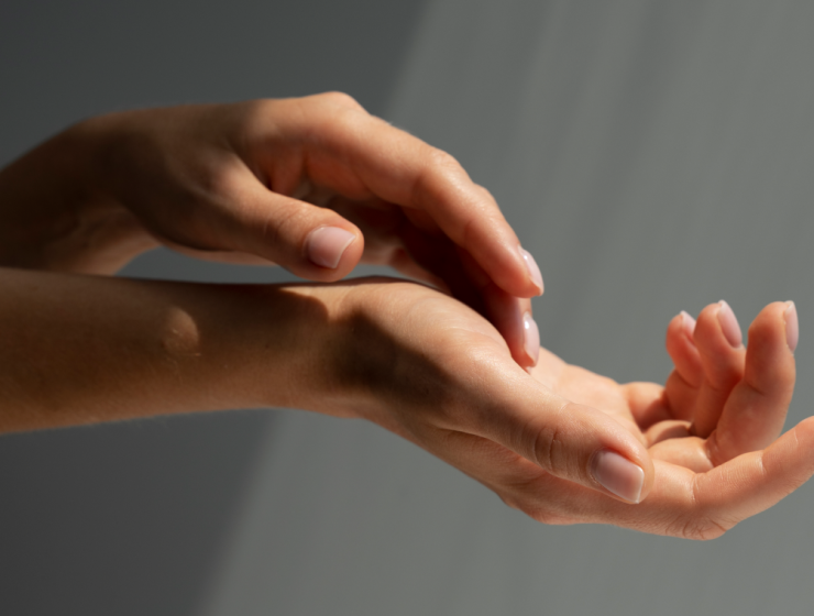 Manos con uñas cuidadas iluminadas suavemente, mostrando un aspecto saludable