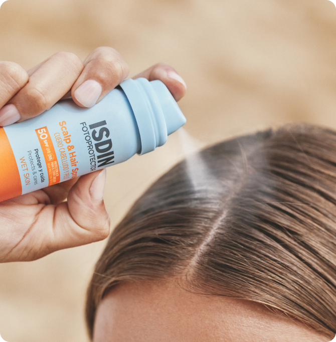 Aplicación de Scalp & Hair Spray SPF 50 de ISDIN sobre la raya del cabello