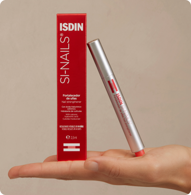 Fortalecedor de uñas ISDIN SI-Nails sostenido sobre una mano, acompañado del estuche rojo del producto.