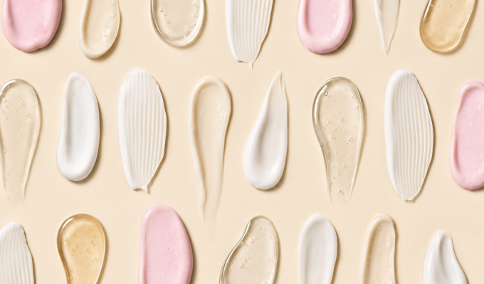 Texturas de sérums, geles y cremas cosméticas sobre un fondo beige.