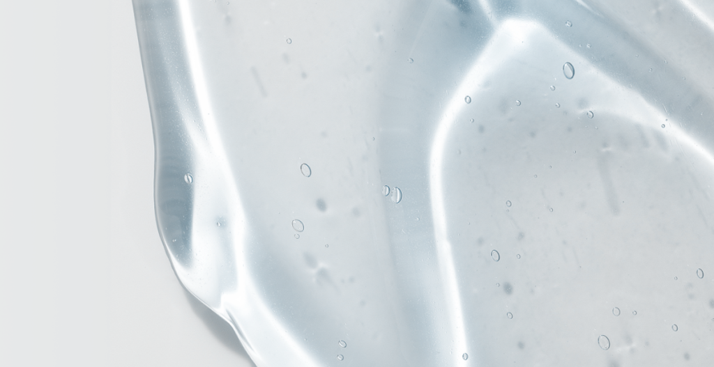 Textura transparente de un sérum cosmético en gel con pequeñas burbujas.