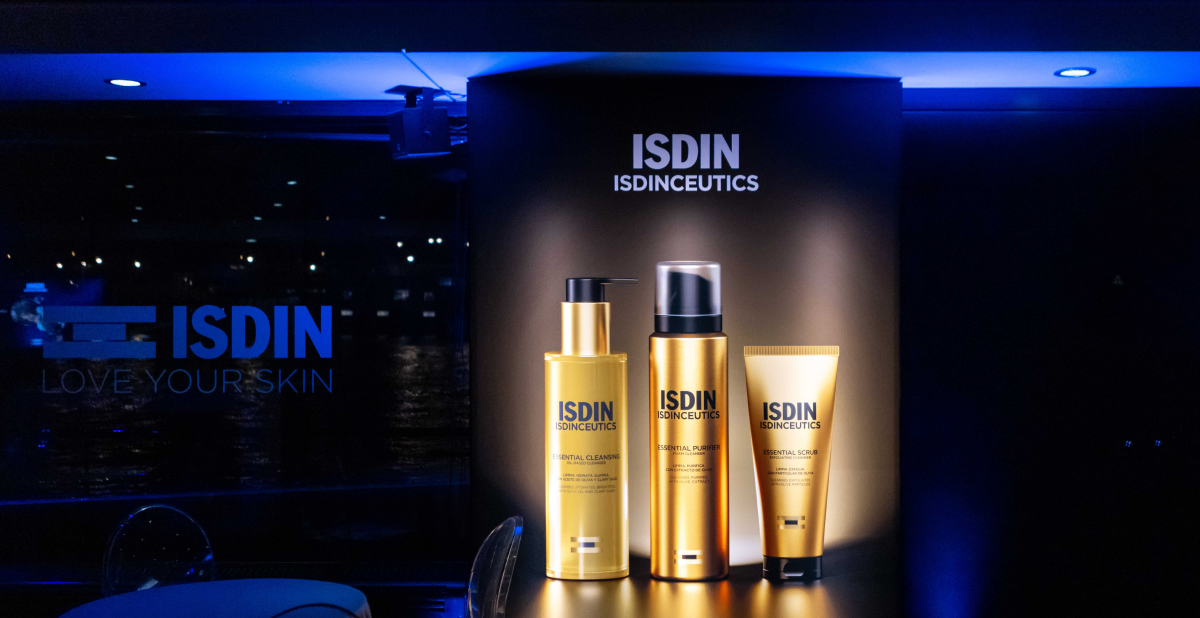 Exposición nocturna de productos ISDINCEUTICS con iluminación elegante frente a una ventana con vistas a París, durante IMCAS 2026.