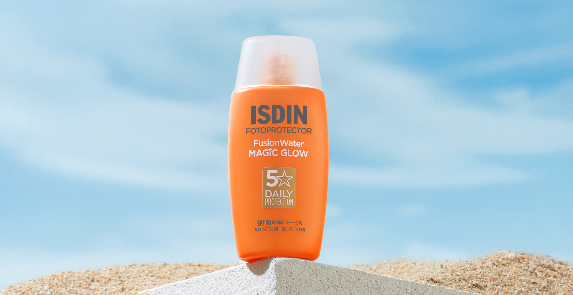 Fotoprotector ISDIN Fusion Water MAGIC GLOW SPF 50 sobre arena, protección solar facial con efecto luminoso