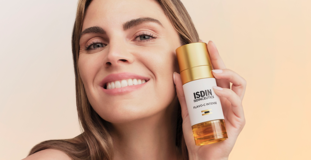 Amaia Salamanca sonriendo mientras muestra sérum ISDIN Flavo-C Intense con piel luminosa