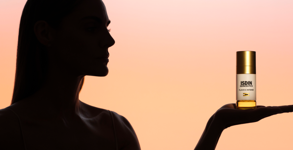 Amaia Salamanca de perfil en contraluz sosteniendo sérum de vitamina C ISDIN Flavo-C Intense