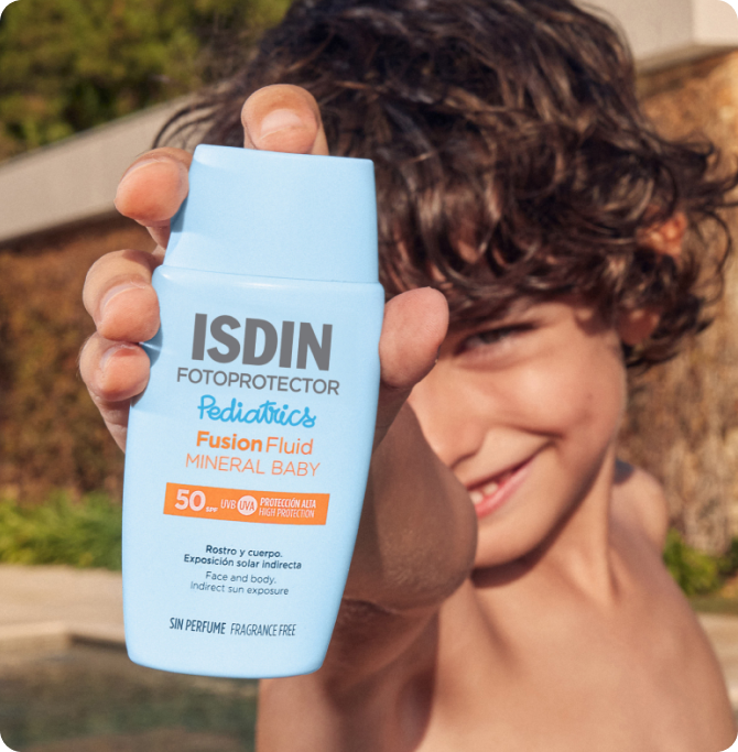 Niño mostrando un envase de fotoprotector Mineral Baby Pediatrics SPF 50.