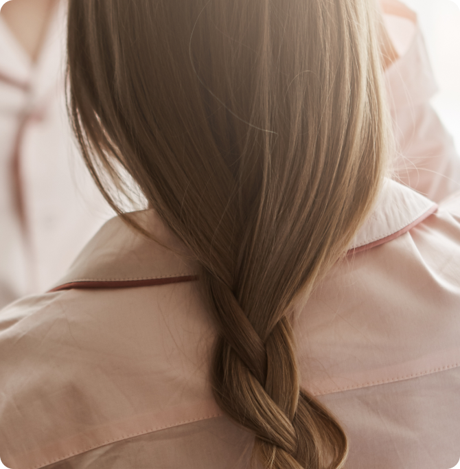 Cabello largo castaño recogido en una trenza suelta.