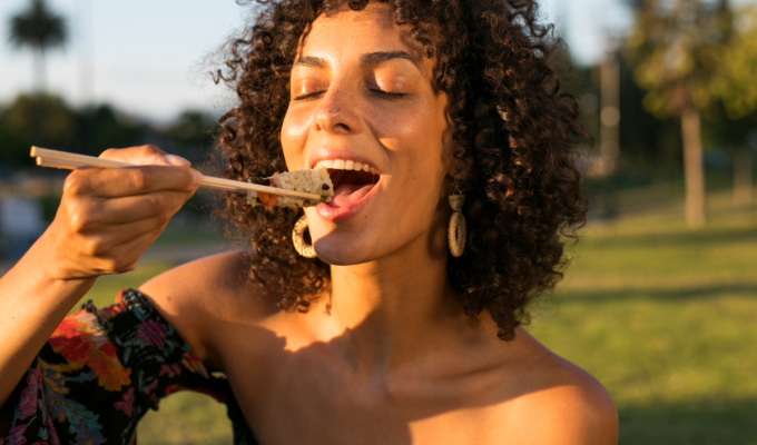 Mujer disfrutando sushi al aire libre