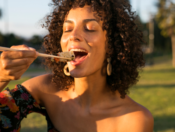 Mujer disfrutando sushi al aire libre