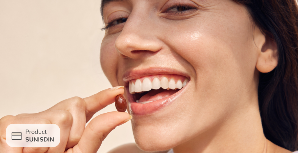 Mujer tomando cápsula de suplemento alimenticio Sunisdin de ISDIN, fuente de vitamina D para complementar la dieta