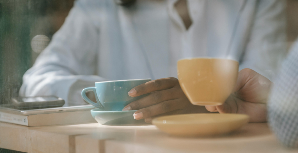 dos chicas bebiendo en tazas de café de color azul y amarillo