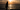 Mujer en silueta frente al mar al atardecer, disfrutando de un momento de calma tras un día de playa