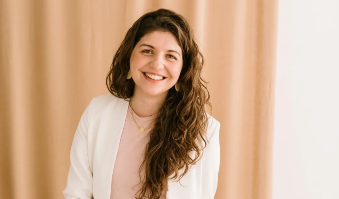 Retrato de anna estape con bata blanca sonriendo, en un entorno neutro, transmitiendo confianza y cercanía.