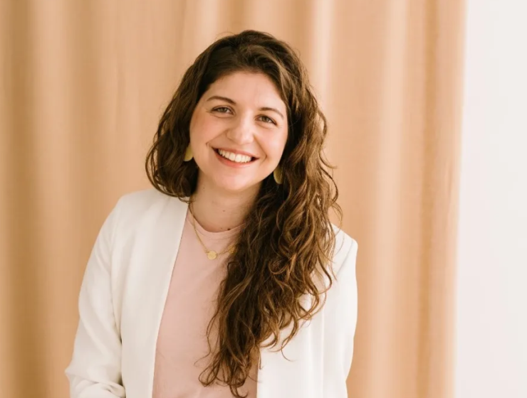 Retrato de anna estape con bata blanca sonriendo, en un entorno neutro, transmitiendo confianza y cercanía.