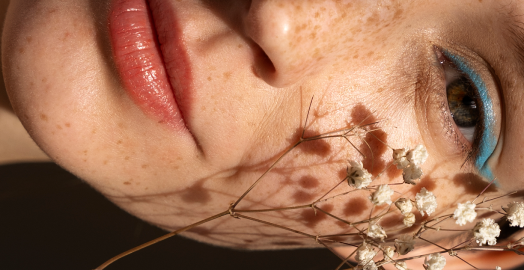 close up de poros de la piel chica con pecas y maquillada